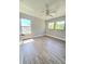 This bedroom has wood-style floors, a ceiling fan, and lots of natural light at 5704 Ansley Way, Mount Dora, FL 32757