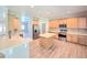 Bright kitchen with wood cabinets, stainless appliances, kitchen island, and modern backsplash at 5704 Ansley Way, Mount Dora, FL 32757