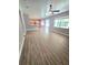 Bright living room with wood-look floors, ceiling fan, and kitchen view at 5704 Ansley Way, Mount Dora, FL 32757