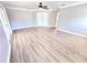 Open concept living room with wood-style floors and double french doors at 5704 Ansley Way, Mount Dora, FL 32757