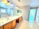Spacious main bathroom with double sinks, tile floors, and large mirrors at 5704 Ansley Way, Mount Dora, FL 32757
