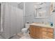 Well-lit bathroom with a striped shower curtain, a classic vanity, and a large framed mirror at 6214 Stevenson Dr # 106, Orlando, FL 32835
