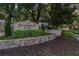 Stonebridge Place entrance sign with stone accents, lush greenery, and mature trees at 6214 Stevenson Dr # 106, Orlando, FL 32835