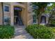 Exterior view showing exterior stairs to upper units, mature tree, and lush landscaping at 6214 Stevenson Dr # 106, Orlando, FL 32835