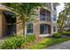 Ground floor view of condo building featuring a screened patio, large window and some mature landscaping at 6214 Stevenson Dr # 106, Orlando, FL 32835