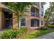Ground floor view of condo building featuring a screened patio, large window and some mature landscaping at 6214 Stevenson Dr # 106, Orlando, FL 32835