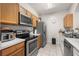 Well-equipped kitchen with stainless steel appliances, wood cabinets, and tile flooring at 6214 Stevenson Dr # 106, Orlando, FL 32835