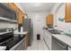 Clean kitchen with wood cabinets, stainless steel appliances, plenty of counter space, and tile flooring at 6214 Stevenson Dr # 106, Orlando, FL 32835