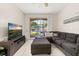 Comfortable living room with a large sectional couch, tile floors, TV, and sliding glass doors to patio at 6214 Stevenson Dr # 106, Orlando, FL 32835