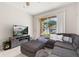 Bright living room featuring a sectional couch, TV, and large sliding glass doors leading to the patio at 6214 Stevenson Dr # 106, Orlando, FL 32835