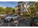 Exterior shot of a two-story condo with parking lot, mature trees, and manicured landscaping at 6214 Stevenson Dr # 106, Orlando, FL 32835