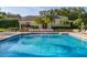 Resort-style community pool and clubhouse surrounded by well-maintained landscaping and palm trees at 6214 Stevenson Dr # 106, Orlando, FL 32835