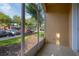 View of a cozy screened patio with a view of the parking and trees on a sunny day at 6214 Stevenson Dr # 106, Orlando, FL 32835