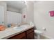 Neutral bathroom featuring a vanity with a stone countertop and a shower with a white patterned curtain at 7144 Five Oaks Dr, Harmony, FL 34773