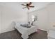 Minimalist bedroom featuring a cozy bed, ceiling fan, and natural light at 7144 Five Oaks Dr, Harmony, FL 34773