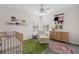 Cozy Bedroom featuring a crib, a cream chair, and decorative wall accents at 7144 Five Oaks Dr, Harmony, FL 34773