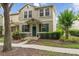 Inviting townhome showcases stone accents, verdant landscaping, and a welcoming green front door at 7144 Five Oaks Dr, Harmony, FL 34773