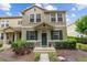 Charming two-story townhome boasts lush landscaping and a welcoming green front door with a wreath at 7144 Five Oaks Dr, Harmony, FL 34773