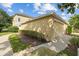 View of the side of the home featuring a two car garage and manicured landscaping at 7144 Five Oaks Dr, Harmony, FL 34773