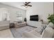 Cozy living room with neutral tones, comfortable sofas, and a large area rug at 7144 Five Oaks Dr, Harmony, FL 34773