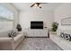 A sunlit living room with plush sofas, a decorative rug, and a large window for natural light at 7144 Five Oaks Dr, Harmony, FL 34773