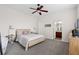 Relaxing bedroom with carpet, a ceiling fan, a cozy bed, and an ensuite bathroom at 7144 Five Oaks Dr, Harmony, FL 34773
