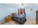 Comfortable bedroom features light blue walls, wood-look flooring, and natural light from two windows at 7222 Stanford Dr, Lakeland, FL 33809