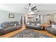 Bright and spacious living room featuring hardwood floors, a ceiling fan, and views into the kitchen at 7222 Stanford Dr, Lakeland, FL 33809