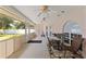 Enclosed sunroom with neutral walls, white trim, ceiling fans, and a glass table with seating for four at 7222 Stanford Dr, Lakeland, FL 33809