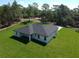 Aerial view of a spacious single-Gathering home with an expansive lawn, dark roof, and rear patio area at 814 Gator Ln, Deltona, FL 32738
