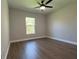 Comfortable bedroom with wood flooring, ceiling fan, and a bright window overlooking the green yard at 814 Gator Ln, Deltona, FL 32738