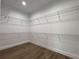 Walk-in closet with white wire shelving and wood-look flooring at 814 Gator Ln, Deltona, FL 32738