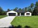 Inviting one-story home with a charming exterior, featuring a well-maintained lawn and attached garage at 814 Gator Ln, Deltona, FL 32738