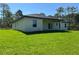 Well-maintained home featuring a back patio, lush green lawn, and a dark roof at 814 Gator Ln, Deltona, FL 32738