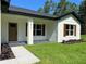 Cozy front porch featuring a stylish door and attractive landscaping with healthy green lawn at 814 Gator Ln, Deltona, FL 32738