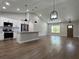 Bright and open living space with cathedral ceilings, wood floors, and adjacent kitchen at 814 Gator Ln, Deltona, FL 32738