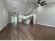 Bright, open-concept living area with wood flooring, vaulted ceiling, and a modern kitchen with a center island at 814 Gator Ln, Deltona, FL 32738