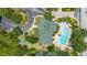 An aerial view showcases a clubhouse with an adjacent swimming pool, patio and nearby parking and lake at 9055 Treasure Trove Ln # 409, Kissimmee, FL 34747
