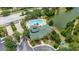 An aerial view of a clubhouse, pool area, parking and surrounding green space and lake at 9055 Treasure Trove Ln # 409, Kissimmee, FL 34747