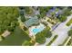 Aerial view showcases the community clubhouse with a swimming pool and nearby parking and lake at 9055 Treasure Trove Ln # 409, Kissimmee, FL 34747