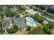 An aerial view of the clubhouse, pool, and amenity center surrounded by lush greenery and a pond at 9055 Treasure Trove Ln # 409, Kissimmee, FL 34747