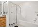 A well-lit bathroom featuring a shower with glass enclosure and a tub with white tiles at 9055 Treasure Trove Ln # 409, Kissimmee, FL 34747