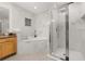 Bright bathroom features a glass-enclosed shower, soaking tub, marble-look tile and wooden vanity at 9055 Treasure Trove Ln # 409, Kissimmee, FL 34747