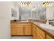 Bright bathroom with marble-look walls, dual sinks, vanity with lights, and bathtub at 9055 Treasure Trove Ln # 409, Kissimmee, FL 34747
