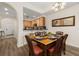 Charming dining area featuring a set dining table, wood flooring, and kitchen access with natural light at 9055 Treasure Trove Ln # 409, Kissimmee, FL 34747
