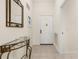 Welcoming foyer featuring decorative mirror, console table, and neutral tile flooring, perfect for a stylish entrance at 9055 Treasure Trove Ln # 409, Kissimmee, FL 34747