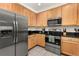 Updated kitchen features stainless steel appliances, wood cabinetry, granite counters and tile flooring at 9055 Treasure Trove Ln # 409, Kissimmee, FL 34747