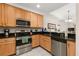 Bright kitchen with stainless steel appliances, wooden cabinets, and granite countertops, with eat in bar at 9055 Treasure Trove Ln # 409, Kissimmee, FL 34747