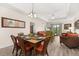 Open-concept living area with dining table and chairs, connecting to a cozy living room, and balcony access at 9055 Treasure Trove Ln # 409, Kissimmee, FL 34747