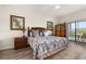 A spacious primary bedroom featuring a ceiling fan, balcony, and wooden furniture at 9055 Treasure Trove Ln # 409, Kissimmee, FL 34747